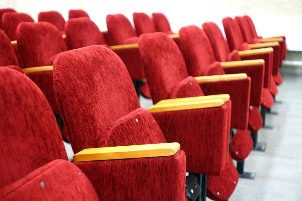 pexels-photo-257385-257385 Empty auditorium rows of plush red velvet theater seats. Perfect for cinema and lecture hall themes.
